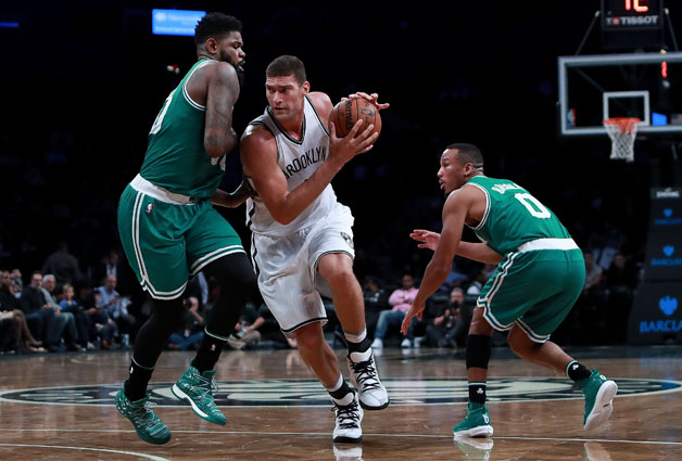 Brook Lopez #11 of the Brooklyn Nets splits the defense of Amir Johnson #90 and Avery Bradley #0 of the Boston Celtics during the first half of the preseason game at Barclays Center on October 13, 2016 in New York City.