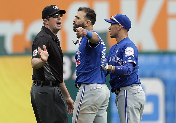 ARLINGTON, TX - MAY 15: Jose Bautista #19 of the Toronto Blue Jays and Ryan Goins #17 argue with MLB umpire Lance Barrett #94 after Bautista was punched by Rougned Odor #12 of the Texas Rangers in the eighth inning at Globe Life Park in Arlington on May 15, 2016 in Arlington, Texas. (Photo by Ronald Martinez/Getty Images)