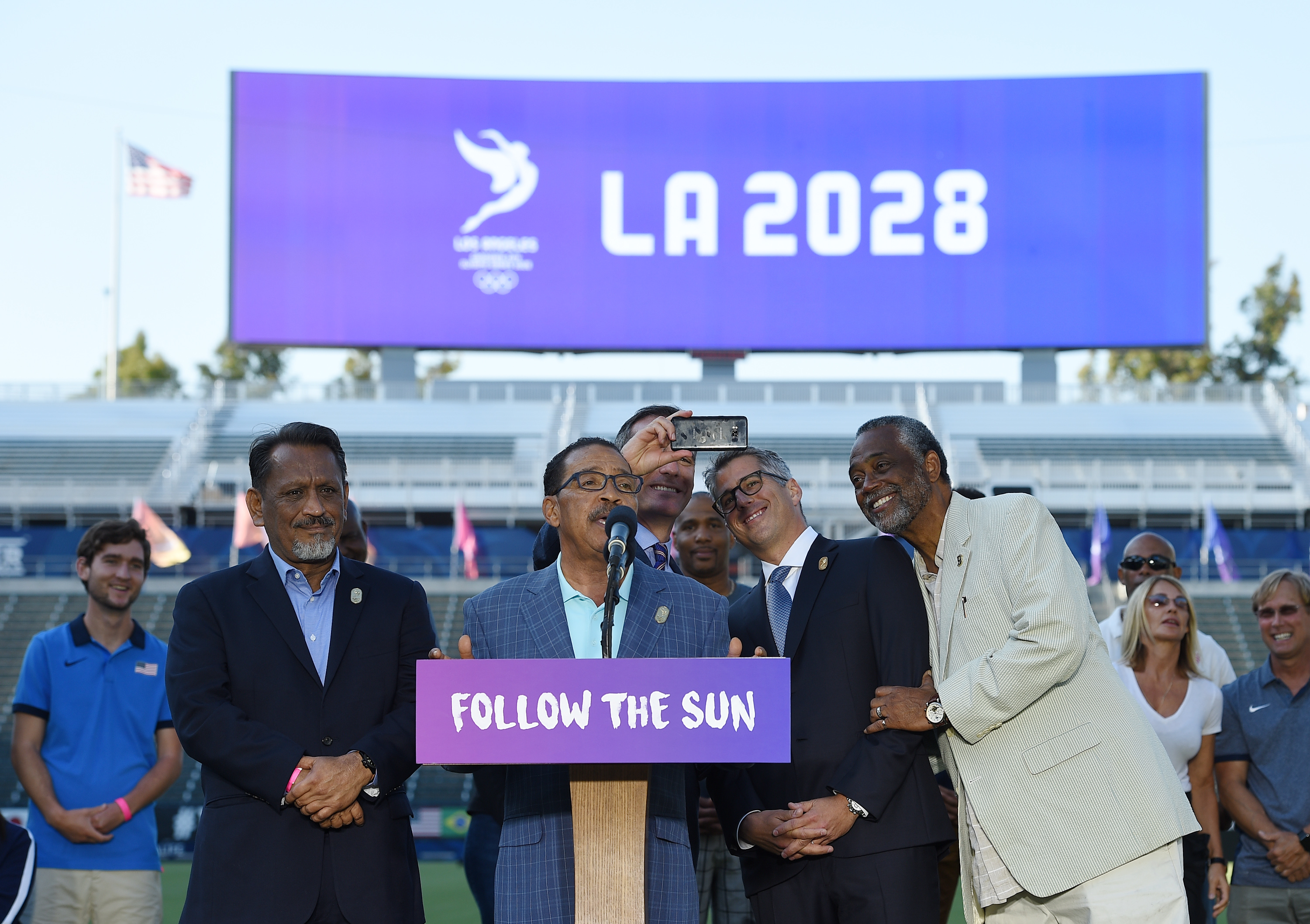 CARSON, CA - JULY 31: Los Angeles Mayor Eric Garcetti takes a selfie with LA 2024 Bid Chairman Casey Wasserman (2nd R) while Los Angeles City Council President Herb Wesson speaks at the podium after announcing a deal with the International Olympic Committee to host the 2028 Summer Olympics during a news conference at StubHub Center July 3, 2017 in Carson, California. 