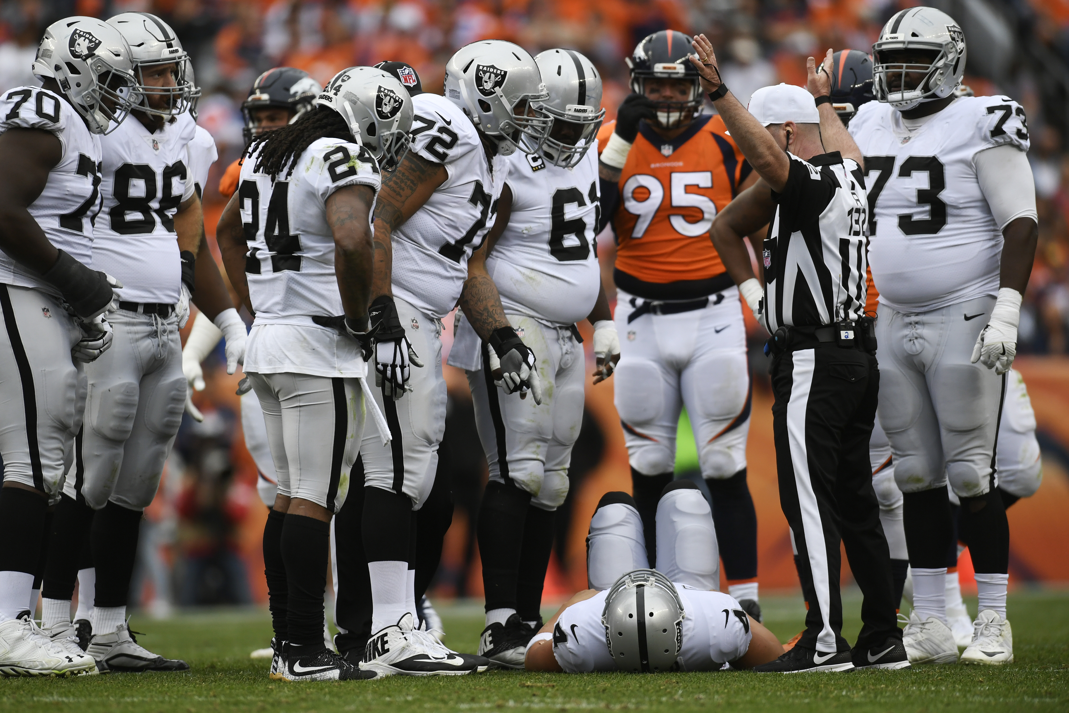 DENVER, CO - OCTOBER 01: Derek Carr (4) of the Oakland Raiders lies on the grass after being hit in the back by Adam Gotsis (99) of the Denver Broncos during the third quarter on Sunday, October 1, 2017. The Denver Broncos hosted the Oakland Raiders.
